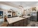 Spacious open-concept kitchen showcasing a large island with seating, stainless steel appliances, and views into the inviting living room at 6905 Clayton St, Mount Dora, FL 32757