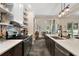 Modern kitchen boasting stainless steel appliances, stylish shelving, and an open layout that seamlessly connects to the dining area at 6905 Clayton St, Mount Dora, FL 32757