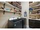 Well-organized laundry room with shelves full of baskets, and modern washer and dryer units at 6905 Clayton St, Mount Dora, FL 32757