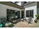 Covered patio with stylish outdoor furniture, offering a relaxing space for entertaining and enjoying the outdoors at 6905 Clayton St, Mount Dora, FL 32757
