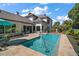 Inviting pool area featuring travertine tile, lush landscaping, and a tranquil atmosphere at 6905 Clayton St, Mount Dora, FL 32757