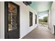 Inviting porch featuring a decorative front door and view of backyard landscaping at 6905 Clayton St, Mount Dora, FL 32757