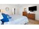 Comfortable bedroom with a dresser, a mounted TV, and a walk-in closet at 8097 Se 174Th Belhaven Loop, The Villages, FL 32162