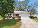Charming single-story home with a two-car garage, lush landscaping, and an inviting entrance at 8097 Se 174Th Belhaven Loop, The Villages, FL 32162