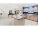 Open concept kitchen featuring a large island, tile floors, and a seamless flow to the dining area at 8097 Se 174Th Belhaven Loop, The Villages, FL 32162