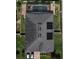Aerial view of the house showcasing a dark roof, screened-in pool, brick paver deck, and well-maintained landscaping at 2504 Cavender Creek Rd, Minneola, FL 34715