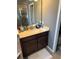 Bathroom vanity with dark wood cabinets, light countertops and a view into the tiled walk-in shower at 2504 Cavender Creek Rd, Minneola, FL 34715