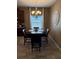 Cozy dining area featuring a dark wood table, four chairs, and natural light from a large window at 2504 Cavender Creek Rd, Minneola, FL 34715