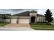 Beautiful single-story house with a three-car garage and well-manicured lawn and landscape at 2504 Cavender Creek Rd, Minneola, FL 34715