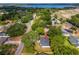 Beautiful aerial view of a home near a lake, surrounded by mature trees and a developing community at 10033 Canterbury Dr, Leesburg, FL 34788