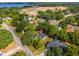 Picturesque aerial view of a home near a lake, surrounded by mature trees and a developing community at 10033 Canterbury Dr, Leesburg, FL 34788