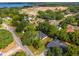 Picturesque aerial view of a home near a lake, surrounded by mature trees and a developing community at 10033 Canterbury Dr, Leesburg, FL 34788