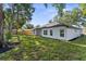 The backyard features a newly renovated home with an expansive lawn and a classic wooden fence at 10033 Canterbury Dr, Leesburg, FL 34788