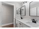Bathroom with dual sinks, marble countertops, black hardware, and modern fixtures at 10033 Canterbury Dr, Leesburg, FL 34788