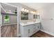 Bright bathroom with a double vanity, large mirror, and a view into the bedroom at 10033 Canterbury Dr, Leesburg, FL 34788