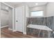 Bright bathroom showcases marble tile accents, soaking tub and white door at 10033 Canterbury Dr, Leesburg, FL 34788