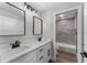 Bathroom with marble-look tile in the shower and a dual sink vanity at 10033 Canterbury Dr, Leesburg, FL 34788