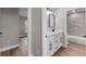 Bathroom with marble-look tile in the shower and a dual sink vanity at 10033 Canterbury Dr, Leesburg, FL 34788