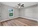 Bedroom featuring wood floors, natural light from the window and a modern ceiling fan at 10033 Canterbury Dr, Leesburg, FL 34788