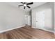 Spacious bedroom with neutral walls, wood floor, ceiling fan and white doors at 10033 Canterbury Dr, Leesburg, FL 34788