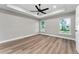 Spacious bedroom featuring hardwood floors, ceiling fan, and large window at 10033 Canterbury Dr, Leesburg, FL 34788