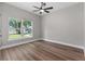 Bright bedroom features neutral walls, wood floor and a window view at 10033 Canterbury Dr, Leesburg, FL 34788