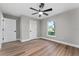 Bedroom featuring wood floors, natural light from the window, walk in closet and a modern ceiling fan at 10033 Canterbury Dr, Leesburg, FL 34788