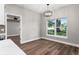 Bright dining room featuring hardwood floors, modern light fixture and large window view at 10033 Canterbury Dr, Leesburg, FL 34788