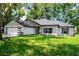 Charming single-story home featuring a two-car garage, well-manicured lawn, and neutral exterior paint at 10033 Canterbury Dr, Leesburg, FL 34788