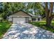 Charming single-story home featuring a two-car garage, well-manicured lawn, and neutral exterior paint at 10033 Canterbury Dr, Leesburg, FL 34788
