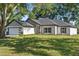 Charming single-story home with a well-manicured lawn, modern garage door, and fresh landscaping at 10033 Canterbury Dr, Leesburg, FL 34788