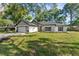 Charming single-story home with a well-manicured lawn, modern garage door, and fresh landscaping at 10033 Canterbury Dr, Leesburg, FL 34788