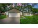 Charming single-story home featuring a two-car garage, well-manicured lawn, and neutral exterior paint at 10033 Canterbury Dr, Leesburg, FL 34788