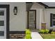 Inviting front entrance with modern accents, stone detail, and a stylish glass-paneled door at 10033 Canterbury Dr, Leesburg, FL 34788