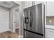 Stainless steel refrigerator with a view of the back hallway and bathroom at 10033 Canterbury Dr, Leesburg, FL 34788