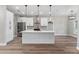 Modern kitchen featuring white cabinets, quartz countertops, stainless steel appliances, and stylish pendant lighting at 10033 Canterbury Dr, Leesburg, FL 34788