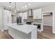 Modern kitchen featuring white cabinets, quartz countertops, stainless steel appliances, and stylish pendant lighting at 10033 Canterbury Dr, Leesburg, FL 34788
