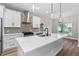 Modern kitchen featuring white cabinets, quartz countertops, stainless steel appliances, and stylish pendant lighting at 10033 Canterbury Dr, Leesburg, FL 34788
