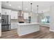 Bright, modern kitchen with white cabinets, stainless steel appliances, and a large island at 10033 Canterbury Dr, Leesburg, FL 34788