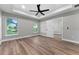 Spacious bedroom with hardwood floors, tray ceiling, ceiling fan and large windows at 10033 Canterbury Dr, Leesburg, FL 34788