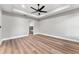 Spacious bedroom with hardwood floors, tray ceiling, ceiling fan and ensuite bathroom at 10033 Canterbury Dr, Leesburg, FL 34788