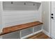 Hallway mudroom boasts custom bench seating, shelving, and storage, with wood-look flooring and black hardware at 10033 Canterbury Dr, Leesburg, FL 34788