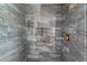 Modern shower featuring elegant marble tile and bronze fixtures at 10033 Canterbury Dr, Leesburg, FL 34788