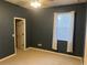 Bedroom with dark blue walls, light carpet, a ceiling fan, a window with white curtains, and a white door at 105 E Blue Water Edge Dr, Eustis, FL 32736