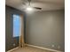 Clean and simple bedroom with neutral-colored walls, tan carpet, a ceiling fan, and a window with white blinds at 105 E Blue Water Edge Dr, Eustis, FL 32736