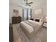 Nicely decorated bedroom with a queen-size bed, nightstands, dresser, modern art, a ceiling fan, and plush carpeting at 105 E Blue Water Edge Dr, Eustis, FL 32736