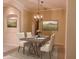 Formal dining room with elegant chandelier, beige walls, and a stylish table set for four at 105 E Blue Water Edge Dr, Eustis, FL 32736