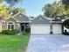 Charming single-story home with a three car garage, a paved driveway, and well-manicured landscaping at 105 E Blue Water Edge Dr, Eustis, FL 32736