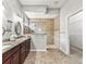 Bathroom featuring double vanity, walk-in shower with glass door, and neutral tile at 10977 Se 169Th Ln, Summerfield, FL 34491