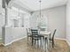 Bright dining room with stylish chandelier, table, chairs and natural light at 10977 Se 169Th Ln, Summerfield, FL 34491